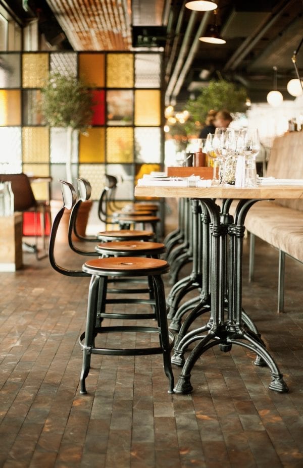 Nicolle metal industrial chair with 45-cm seat height and a suede fawn leather cushion - Chaises Nicolle and bistro table in a restaurant in Sweden