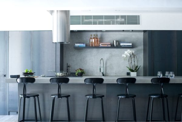 Sleek kitchen with concrete bar and stylish Chaises Nicolle industrial metal chairs