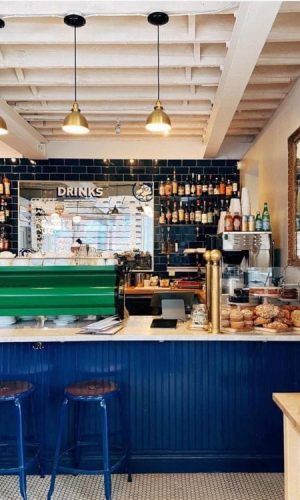 Chaises Nicolle 60-cm metal stool. Nicolle blue stools at the counter of a shop in the USA.