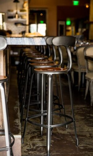 Nicolle bar stool with leather seatpad and backrest, perfect for restaurants and cafés.