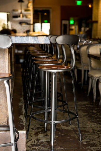 Nicolle bar stool with leather seatpad and backrest, perfect for restaurants and cafés.