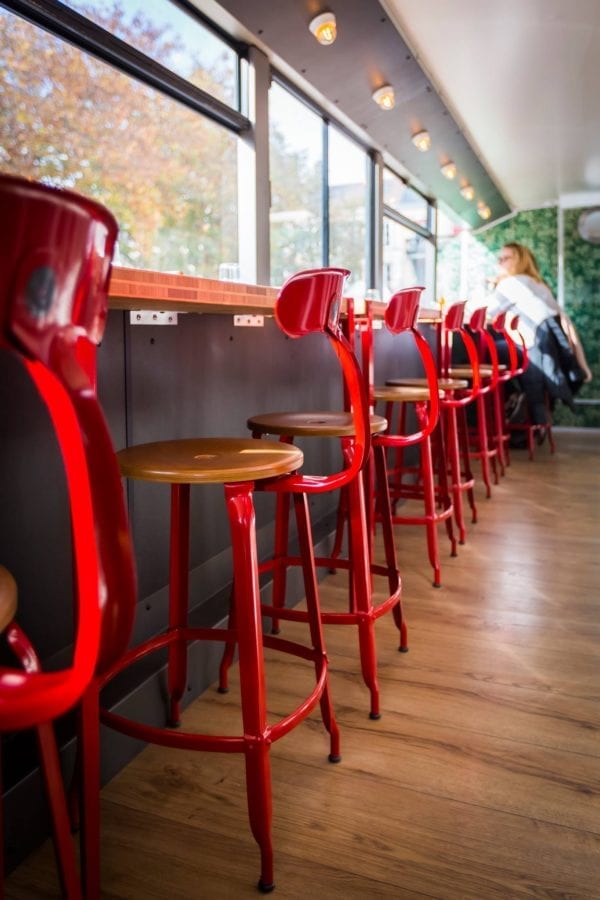 Red Chaises Nicolle made of wood and metal in a burger restaurant